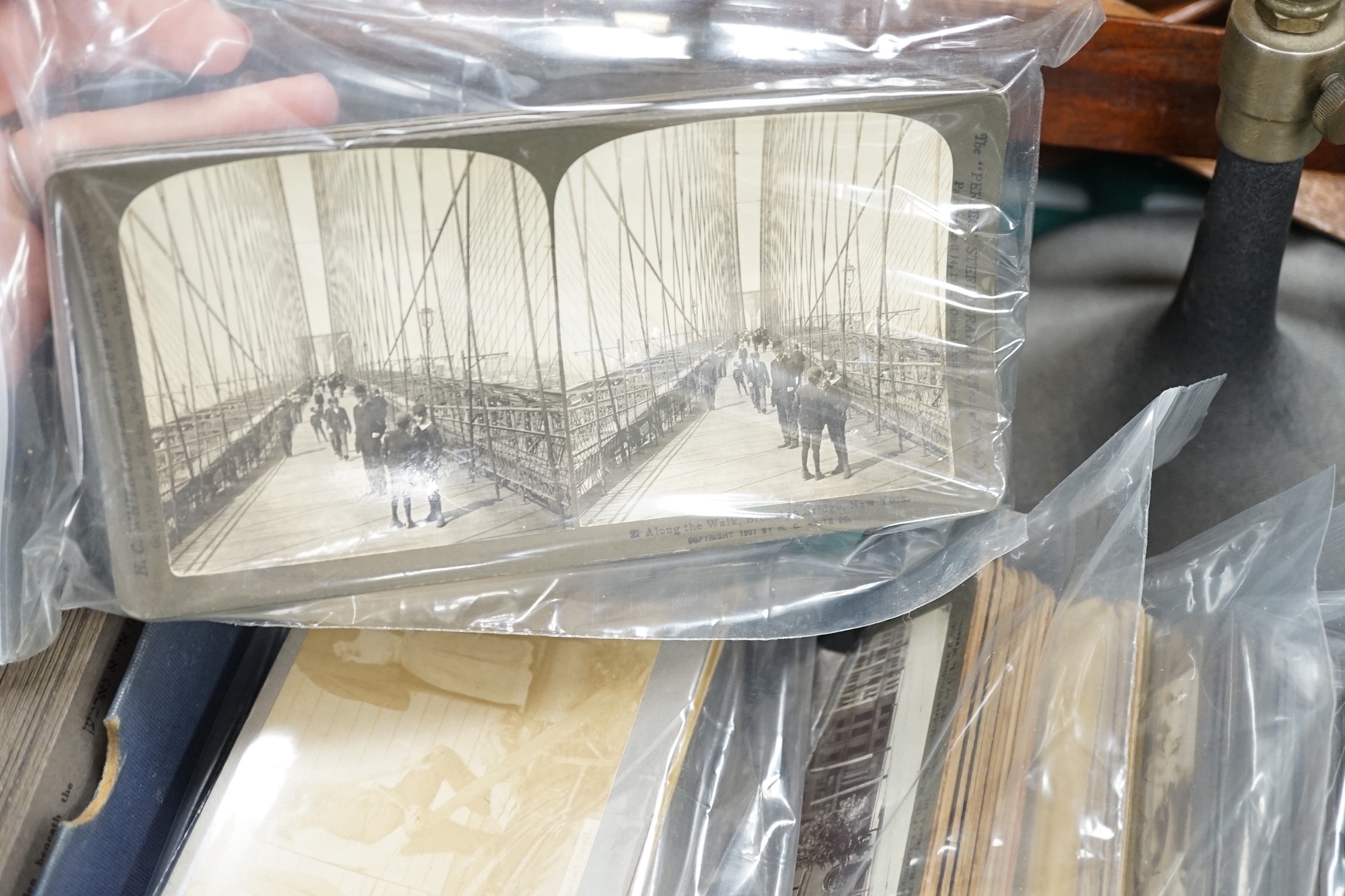A collection of stereographic photo cards, six various hand held viewers and a black lacquered metal adjustable desk stereo viewer with lamp attachment